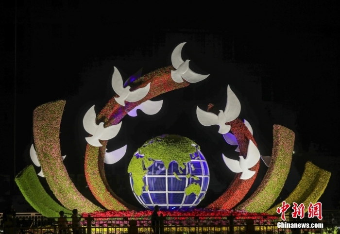 資料圖：2022年9月26日晚，北京長安街沿線國慶主題花壇亮燈，市民在參觀軍事博物館前廣場佈置的“命運共同體”花壇。 <a target='_blank' href='/'>中新社</a>記者 易海菲 攝